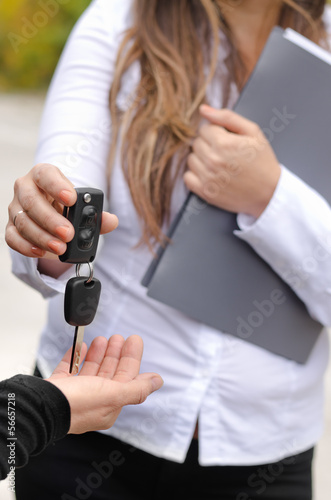 Photo: Saleswoman handing over the keys to a car Saleswoman handing over the keys to a car