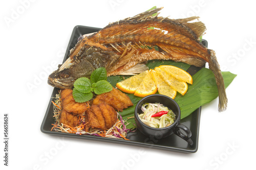 Photo: Fish fried with spicy mango salad in the black plate Fish fried with spicy mango salad in the black plate