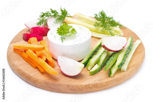 Photo: sauce with feta cheese and assorted vegetables on a wooden board sauce with feta cheese and assorted vegetables on a wooden board