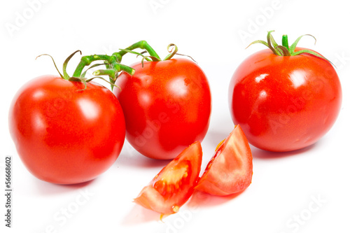 Photo: Closeup of tomatoes on the vine isolated on white. Tomato branch Closeup of tomatoes on the vine isolated on white. Tomato branch