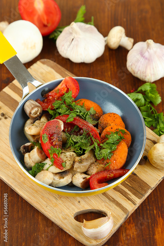 Photo: Sliced fresh vegetables in pan on wooden table close-up Sliced fresh vegetables in pan on wooden table close-up
