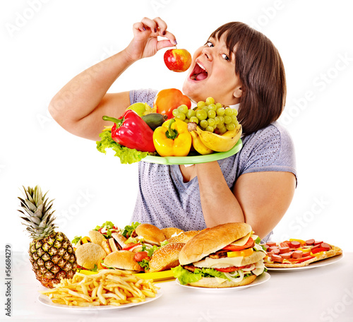 Photo: Woman choosing between fruit and hamburger. Woman choosing between fruit and hamburger.