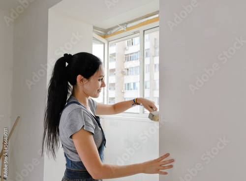Photo: Woman painting a wall with a paintbrush Woman painting a wall with a paintbrush