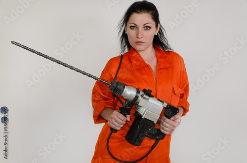 Photo: Competent woman with a masonry drill Competent woman with a masonry drill