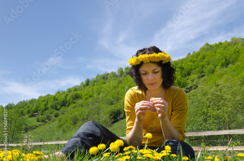 Photo: A young woman making a garland of flowers A young woman making a garland of flowers