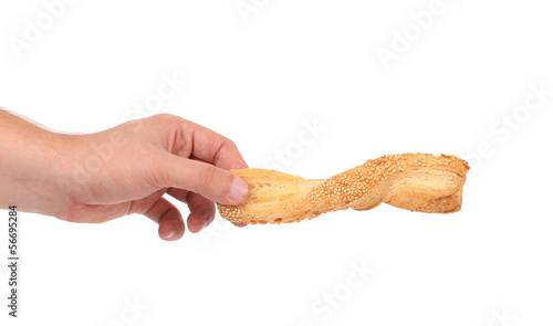 Photo: Hand holds of puff pastry stick Hand holds of puff pastry stick