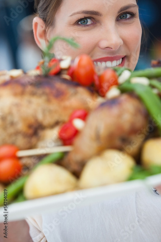 Photo: Pretty woman showing roast chicken Pretty woman showing roast chicken