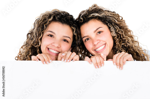 Photo: Twin sisters holding banner Twin sisters holding banner