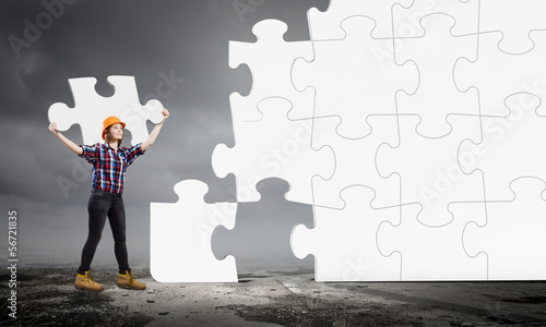 Photo: Woman engineer with puzzle Woman engineer with puzzle