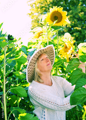 Photo: Frau im Spätsommer mit großen Sonnenblumen Frau im Spätsommer mit großen Sonnenblumen