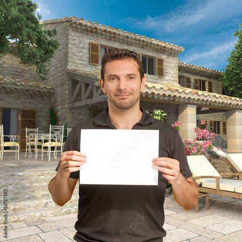 Photo: Man with message by beautiful house Man with message by beautiful house