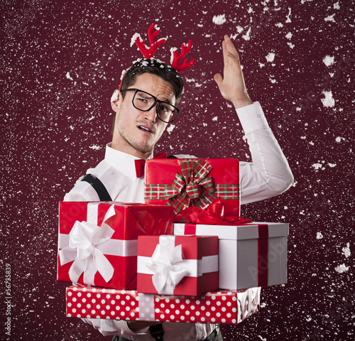 Photo: Grimacing man with stack of christmas presents Grimacing man with stack of christmas presents
