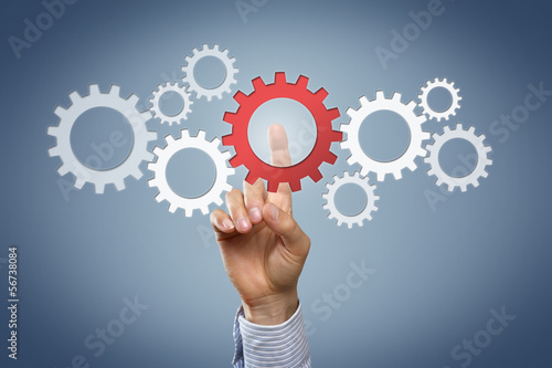 Photo: Hand touching cogwheels Hand touching cogwheels