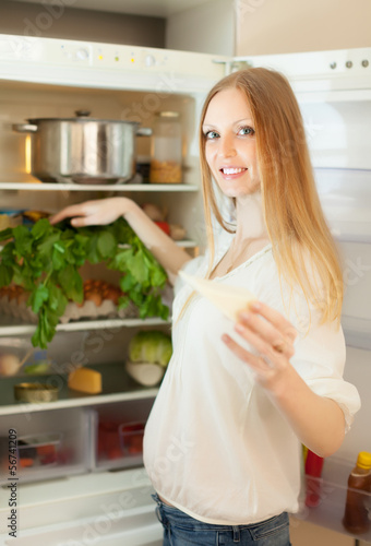 Photo: long-haired woman near opened refrigerator long-haired woman near opened refrigerator