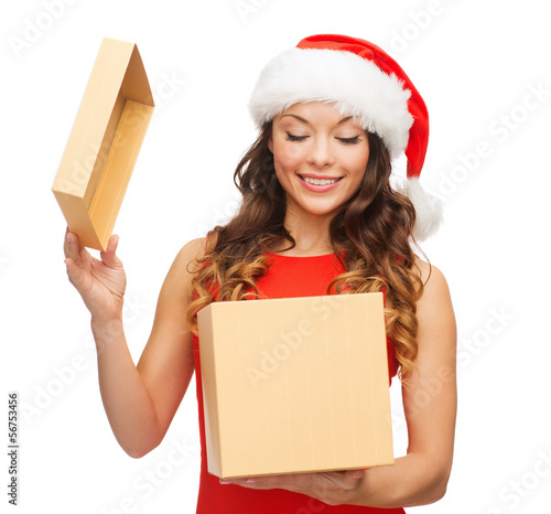 Photo: smiling woman in santa helper hat with gift box smiling woman in santa helper hat with gift box