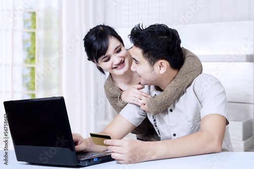 Photo: Happy asian couple online shoping at home Happy asian couple online shoping at home