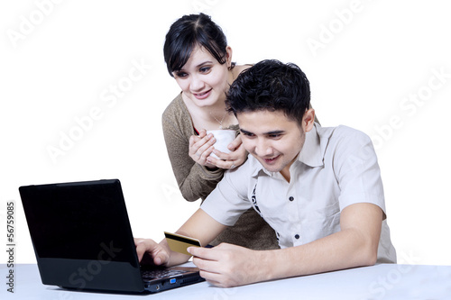 Photo: Isolated young couple online shopping Isolated young couple online shopping