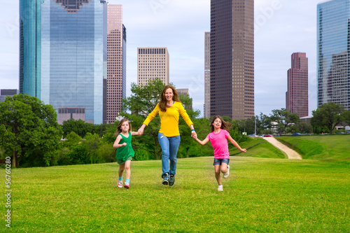 Photo: Mother and daughters walking holding hands on city skyline Mother and daughters walking holding hands on city skyline