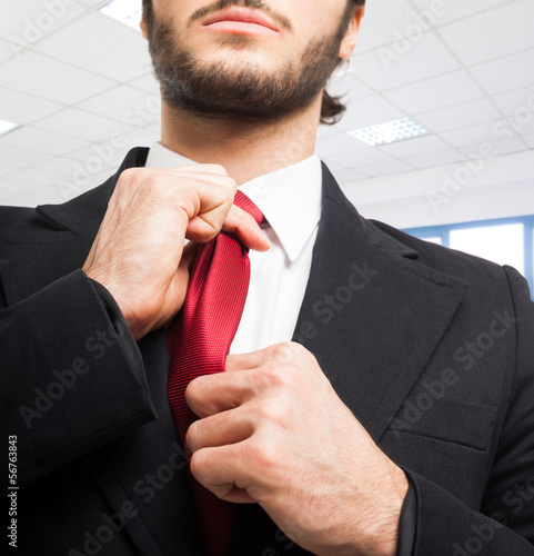 Photo: Businessman adjusting his tie Businessman adjusting his tie