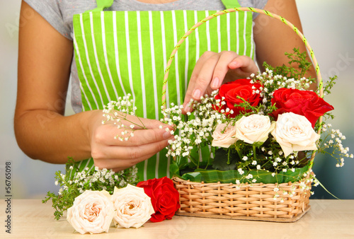Photo: Florist makes flowers bouquet in wicker basket Florist makes flowers bouquet in wicker basket