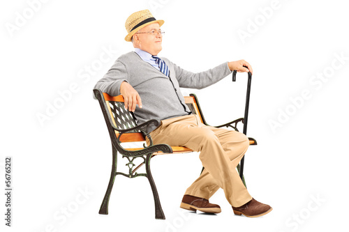 Photo: Relaxed senior man sitting on a wooden bench and thinking Relaxed senior man sitting on a wooden bench and thinking