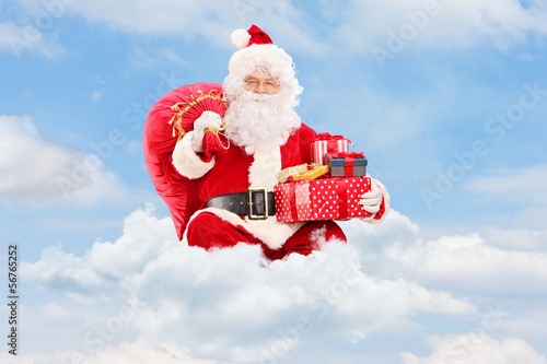 Photo: Santa Claus seated on clouds holding a bag Santa Claus seated on clouds holding a bag
