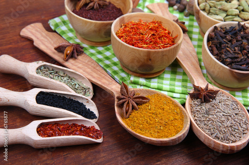 Photo: Various spices and herbs on wooden background Various spices and herbs on wooden background