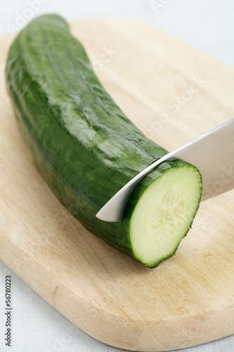 Photo: Salatgurke wird in Scheiben geschnitten Salatgurke wird in Scheiben geschnitten
