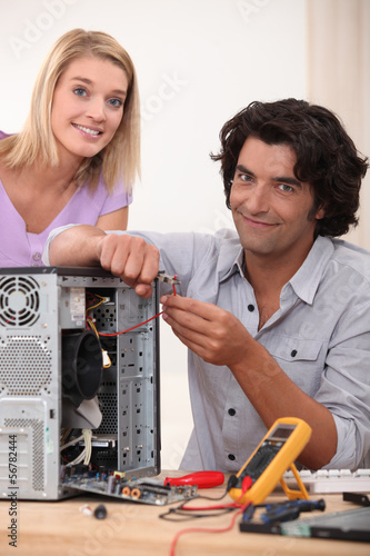 Photo: Woman watching her husband repair a computer Woman watching her husband repair a computer