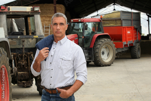 Photo: Farmer stood in front of tractors Farmer stood in front of tractors