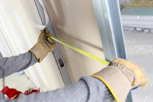 Photo: Skilled worker measuring wall Skilled worker measuring wall