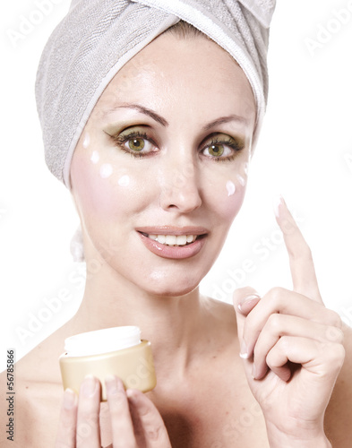 Photo: The beautiful young woman in towel with a cosmetic cream.. The beautiful young woman in towel with a cosmetic cream..