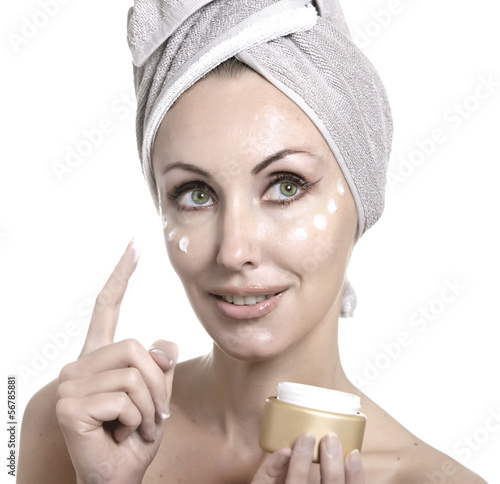 Photo: The beautiful young woman in towel with a cosmetic cream.. The beautiful young woman in towel with a cosmetic cream..