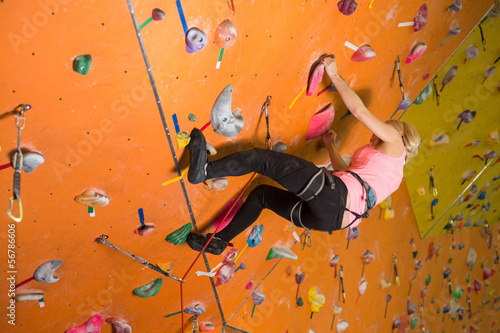 Photo: The girl climbs the steep wall on the climbing gym The girl climbs the steep wall on the climbing gym