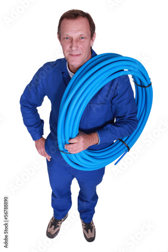 Photo: Plumber with coil of piping Plumber with coil of piping