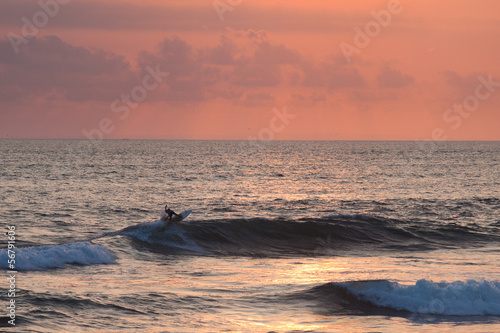 Photo: Surfer at sunset in Ocean Wave in Bali, Indonesia Surfer at sunset in Ocean Wave in Bali, Indonesia