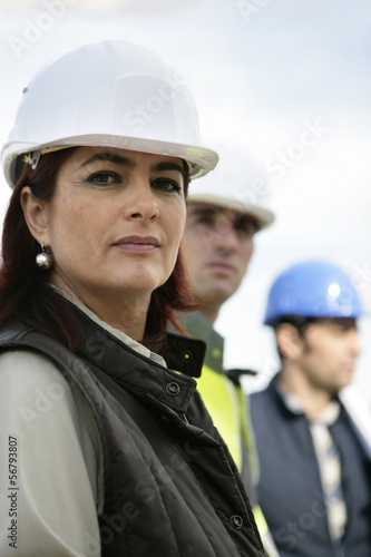 Photo: Three construction colleagues standing in a row Three construction colleagues standing in a row