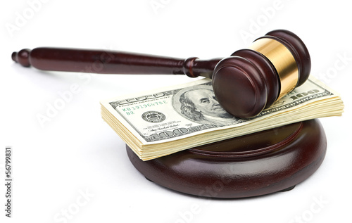 Photo: Law gavel on a stack of American money. Law gavel on a stack of American money.