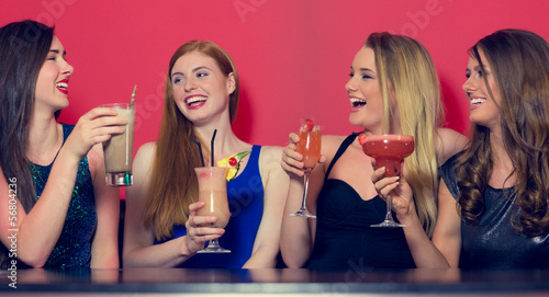 Photo: Attractive friends clubbing holding cocktails Attractive friends clubbing holding cocktails