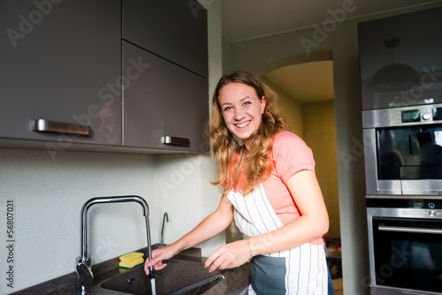Photo: Happy Young Woman Washing cup. Kitchen. Dishwashing. Happy Young Woman Washing cup. Kitchen. Dishwashing.