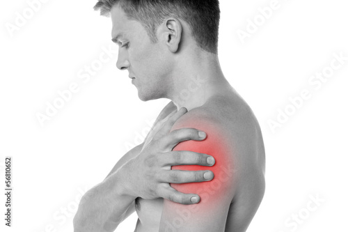 Photo: Guy holding his shoulder in pain Guy holding his shoulder in pain