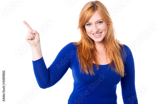 Photo: Young woman pointing away over white Young woman pointing away over white