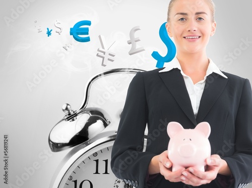 Photo: Blonde businesswoman holding piggy bank Blonde businesswoman holding piggy bank