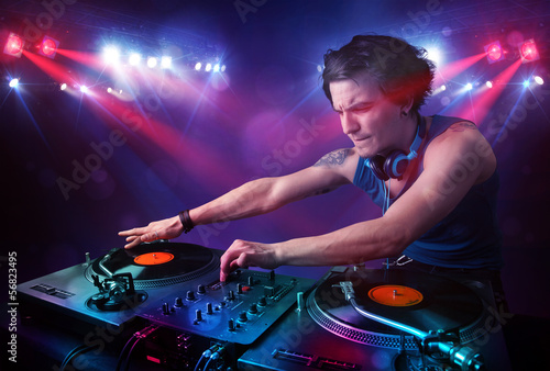 Photo: Teenager dj mixing records in front of a crowd on stage Teenager dj mixing records in front of a crowd on stage