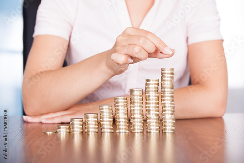 Photo: Woman Hand Stacking Gold Coin Woman Hand Stacking Gold Coin