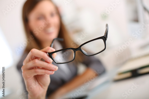 Photo: Closeup of eyeglasses held by businesswoman Closeup of eyeglasses held by businesswoman