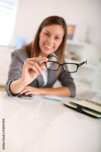Photo: Closeup of eyeglasses held by businesswoman Closeup of eyeglasses held by businesswoman