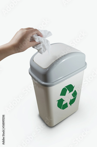 Photo: hand putting a paper garbage into recycling bin hand putting a paper garbage into recycling bin