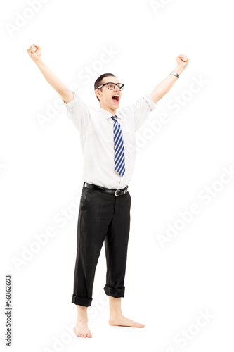Photo: Excited barefooted guy with raised hands gesturing happiness Excited barefooted guy with raised hands gesturing happiness