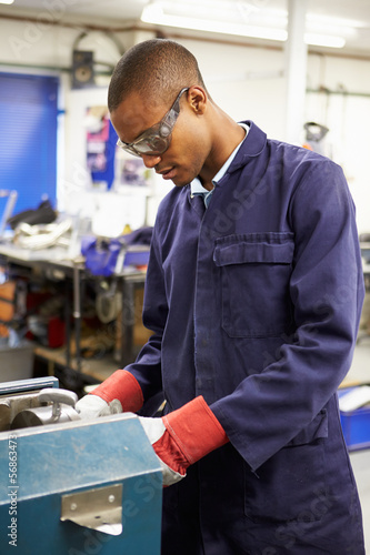 Photo: Apprentice Engineer Working On Factory Floor Apprentice Engineer Working On Factory Floor